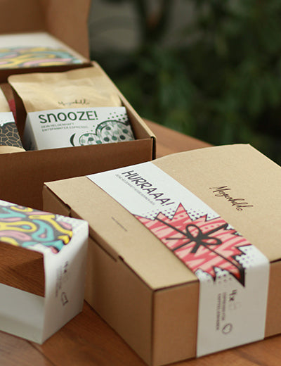 „Morgenheld Probierbox HURRAAA! mit vier 250‑g Kaffeepackungen – BÄÄMM!!, ZACK!!, LOVE! und CREAMY! – farbenfrohe Superkraft‑Röstungen in einer Geschenkbox.