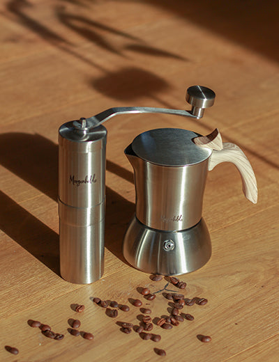 Morgenheld Kaffeekocher und manuelle Handmühle auf einem Tisch