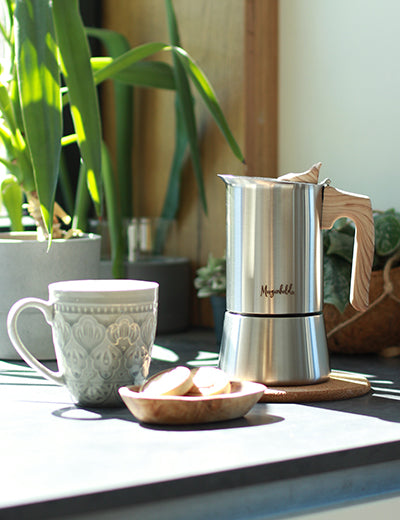 Morgenheld Espressokocher STYLE mit einer schönen Tasse Kaffee auf dem Tisch