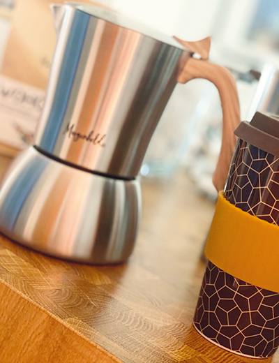 Edelstahl-Espressokocher von Morgenheld auf einem Küchentresen neben dem Morgenheld Brownie To-go-Kaffeebecher